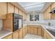 Bright kitchen featuring a window over the double sink and light wood cabinetry at 544 S Xenon Ct, Lakewood, CO 80228