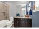 Traditional bathroom with a tiled shower/tub combination, dark wood vanity, and a large mirror at 3434 Antelope Ridge Trl, Parker, CO 80138
