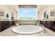 Beautiful bathroom showcasing a large soaking tub set with beautiful views, double sinks, and sleek cabinets at 3434 Antelope Ridge Trl, Parker, CO 80138