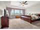 Spacious bedroom with a tray ceiling, a large window, and a comfortable bed and matching furniture at 3434 Antelope Ridge Trl, Parker, CO 80138