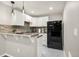 Well-lit kitchen features white cabinets, modern appliances, decorative backsplash, and a breakfast bar at 3434 Antelope Ridge Trl, Parker, CO 80138