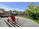Outdoor deck featuring red chairs and a cozy rug, creating a relaxing space in the well-maintained backyard at 2588 E 116Th Ave, Thornton, CO 80233