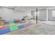 Spacious basement area with colorful mats, ideal for a playroom or flexible living space at 2588 E 116Th Ave, Thornton, CO 80233