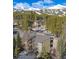 Aerial view shows complex nestled among snow covered mountains and mature evergreens at 1179 Ski Hill Rd # 147, Breckenridge, CO 80424