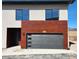 Exterior of home with a gray garage door, wood paneling, modern windows, and number 103 above the garage at 241 N Front St # 103, Monument, CO 80132