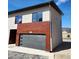 Side view of exterior of home with a gray garage door, wood paneling, modern windows, and number 103 above garage at 241 N Front St # 103, Monument, CO 80132