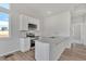 Kitchen with white cabinets, granite counters, stainless appliances, island with sink, and wood flooring at 241 N Front St # 103, Monument, CO 80132