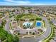 Expansive community aerial view showcasing a playground, pool, tennis court, and green spaces with surrounding homes at 18056 E 104Th Way, Commerce City, CO 80022