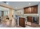 Charming home bar featuring granite countertops, rich wood cabinetry, stainless steel appliances, and barstool seating at 10646 Winding Pine Pt, Highlands Ranch, CO 80126