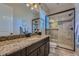 Bathroom featuring a granite countertop, undermount sink, and tiled glass-enclosed shower at 10646 Winding Pine Pt, Highlands Ranch, CO 80126