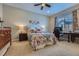 Cozy bedroom with a floral bedspread, a crib, a ceiling fan, and a dedicated desk area at 10646 Winding Pine Pt, Highlands Ranch, CO 80126