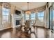 Bright dining area with a fireplace, hardwood floors, and beautiful windows showcasing the landscape at 10646 Winding Pine Pt, Highlands Ranch, CO 80126