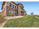 Stunning exterior elevation featuring stone accents, a spiral staircase and lush green lawn at 10646 Winding Pine Pt, Highlands Ranch, CO 80126