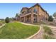 Beautiful exterior elevation featuring stone accents, a balcony and green landscaping at 10646 Winding Pine Pt, Highlands Ranch, CO 80126