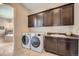 Laundry room with front load washer and dryer, upper cabinets, and utility sink with countertops at 10646 Winding Pine Pt, Highlands Ranch, CO 80126