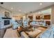 Open-concept living area with a stone fireplace, hardwood floors, and seamless flow to the kitchen at 10646 Winding Pine Pt, Highlands Ranch, CO 80126