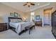 Well-lit main bedroom featuring a tray ceiling, neutral carpet, and a leather bench at the foot of the bed at 10646 Winding Pine Pt, Highlands Ranch, CO 80126