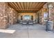 Covered patio featuring stone columns, wood ceiling and outdoor dining furniture at 10646 Winding Pine Pt, Highlands Ranch, CO 80126