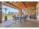 Covered patio with stone columns, wood ceiling and outdoor dining furniture at 10646 Winding Pine Pt, Highlands Ranch, CO 80126