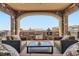 A welcoming outdoor patio featuring stone accents, a built-in grill, and comfortable seating for relaxation and entertainment at 10646 Winding Pine Pt, Highlands Ranch, CO 80126
