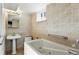 Bathroom with tub, pedestal sink and tile surround at 12162 W Dakota Dr, Lakewood, CO 80228