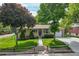Well-maintained ranch-style home with mature trees and a lush green lawn at 12162 W Dakota Dr, Lakewood, CO 80228