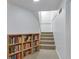 Basement stairs lead to finished area, with a built-in bookcase adding charm and functionality at 9424 E Girard Ave, Denver, CO 80231