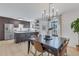 Open-concept dining area adjacent to a modern kitchen, with a dark wood table and contemporary chairs at 9424 E Girard Ave, Denver, CO 80231