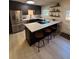 Modern kitchen boasts stainless steel appliances, a large island with barstool seating, and sleek black cabinets at 9424 E Girard Ave, Denver, CO 80231