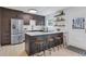 Modern kitchen featuring stainless steel appliances, a kitchen island with seating, and dark wood cabinetry at 9424 E Girard Ave, Denver, CO 80231