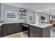 Contemporary kitchen with an island cooktop, white countertops, dark cabinets, and ample natural light at 9424 E Girard Ave, Denver, CO 80231