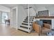 Interior view of a staircase adjacent to a living area featuring modern decor and a cozy fireplace at 9424 E Girard Ave, Denver, CO 80231