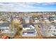 Aerial view of a home with solar panels, a covered patio, and a fenced backyard in a residential neighborhood at 3764 Balderas St, Brighton, CO 80601