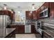 Modern kitchen featuring stainless steel appliances, granite countertops, a tile backsplash, and dark wood cabinetry at 3764 Balderas St, Brighton, CO 80601