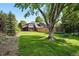 Large, manicured backyard with lush green grass and mature trees. Fenced in area and trampoline included at 5441 S Dayton Ct, Greenwood Village, CO 80111