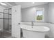 Bathroom featuring a standalone tub under a bright window, complemented by a sleek glass shower at 5441 S Dayton Ct, Greenwood Village, CO 80111