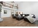 Spacious living room features hardwood floors, a dark leather sofa and natural light from the second story at 5441 S Dayton Ct, Greenwood Village, CO 80111
