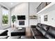 Open living room features a brick fireplace, large windows, and access to the second story landing at 5441 S Dayton Ct, Greenwood Village, CO 80111