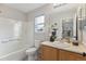 Bright bathroom with white bathtub, single vanity, and large mirror with overhead lighting at 4526 Lyndenwood Pt, Highlands Ranch, CO 80130