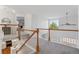 Upstairs hallway with wood and white railings overlooking the kitchen and living area at 4526 Lyndenwood Pt, Highlands Ranch, CO 80130