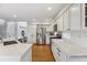 Modern kitchen featuring white cabinets, stainless steel appliances, and hardwood floors at 4526 Lyndenwood Pt, Highlands Ranch, CO 80130