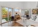 Bright living room featuring hardwood floors, stylish furnishings, and sliding glass doors to the backyard at 4526 Lyndenwood Pt, Highlands Ranch, CO 80130