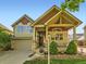 Inviting two-story home boasts a covered front porch with stone pillars and manicured landscaping at 301 Harvest St, Longmont, CO 80501