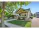 Charming home featuring a well-maintained lawn and a welcoming front porch with stone accents and a manicured garden at 301 Harvest St, Longmont, CO 80501