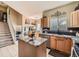 Bright kitchen with stainless steel appliances, granite countertops, an island, and an open view of the staircase at 301 Harvest St, Longmont, CO 80501