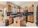 Modern kitchen features a center island with granite countertops, stainless steel appliances, and wooden cabinets at 301 Harvest St, Longmont, CO 80501