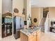 Spacious kitchen with an island, stainless steel refrigerator, and a view of the staircase and adjacent living area at 301 Harvest St, Longmont, CO 80501