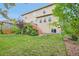 Expansive backyard boasts a green lawn, mature trees, and a charming deck for relaxation and recreation at 594 Fall River Ct, Brighton, CO 80601