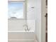 Modern white bathtub next to a window and a doorway at 594 Fall River Ct, Brighton, CO 80601