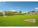 Community green space with a walking path, grassy area, and mature trees at 594 Fall River Ct, Brighton, CO 80601